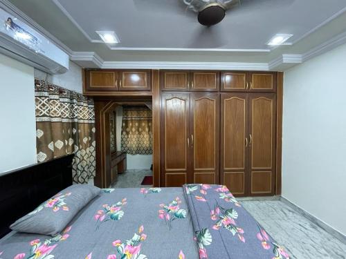 a bedroom with a bed and wooden cabinets at 5 Fully Furnished 2 BHK Flats in MVP Colony, Vizag in Visakhapatnam