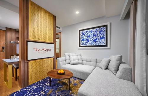 a living room with a couch and a table at The Alana Hotel Malang in Malang