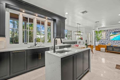 una cocina con armarios negros y fregadero en Florida Keys Villa Beach Proximity Heated Pool Serenity at its Finest Hemingway Key VlLLAS, en Fort Lauderdale