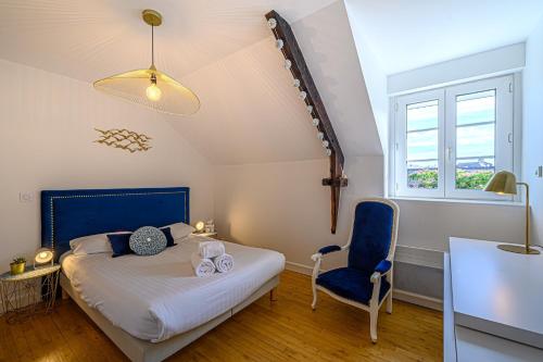 une chambre avec un lit et une chaise bleue dans l'établissement TY ELISTHER - Maison de charme à Saint-Colombier, à Sarzeau