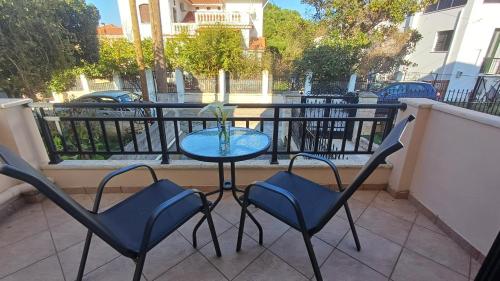 a table and two chairs on a balcony at Studio Apartments Eirini in Pyrgi Thermis