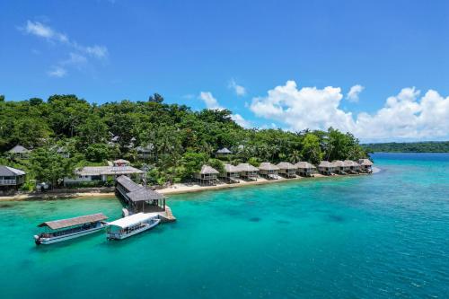 an island with a resort and boats in the water at Iririki Island Resort & Spa in Port Vila