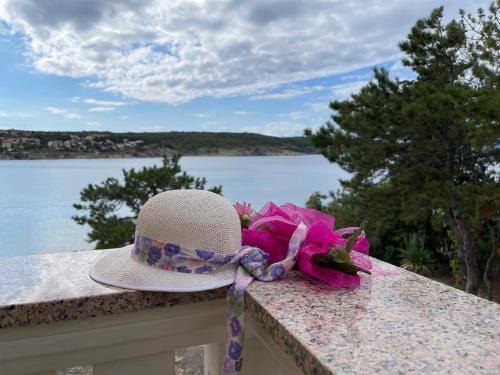 a hat sitting on a ledge with a bow at Villa Tiha Lili in Šilo