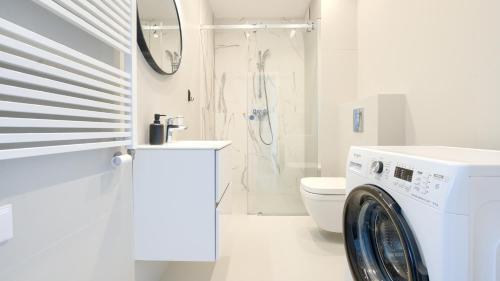 een wasmachine in een badkamer met een toilet bij Apartamenty Sun & Snow Euronia in Międzyzdroje
