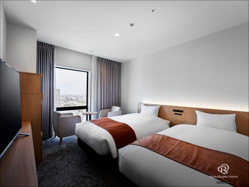a hotel room with two beds and a window at Daiwa Roynet Hotel Omiya-nishiguchi in Saitama