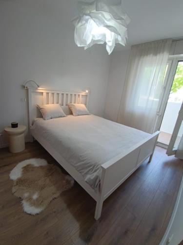 1 cama blanca en un dormitorio con ventana en Apartman Petra, en Split