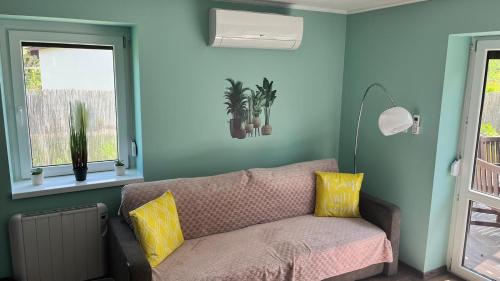 a living room with a couch and two windows at Habitat of Dreams in Makó