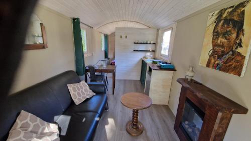 un salon avec un canapé et une table dans l'établissement De pipowagens van het Château, à Viviez