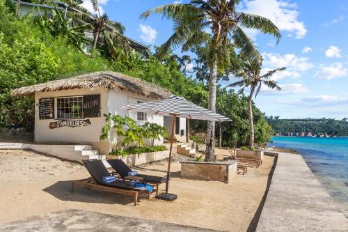 a resort with two lounge chairs on the beach at Iririki Island Resort & Spa in Port Vila