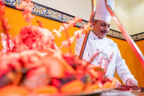 a chef standing in front of a table of food at Faraana Heights Aqua Park in Sharm El Sheikh