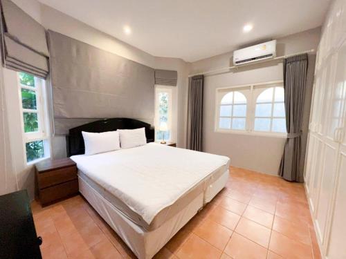 a bedroom with a large bed and two windows at Prime Hill , Kathu Phuket / C2 in Ban Ket Ho