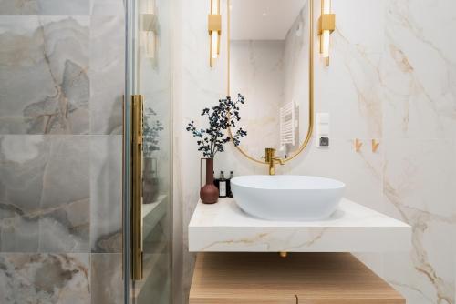 a bathroom with a sink and a mirror at Sol Marina Resort Wyspa Sobieszewska II - LoftAffair Collection in Wiślinka