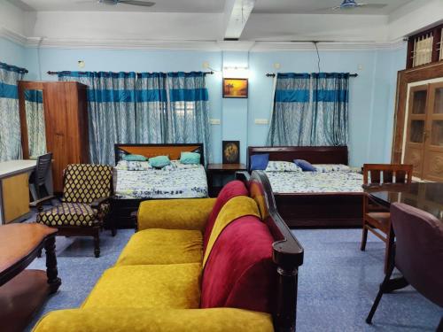 a living room with two beds and a couch at The Imperial Homestay, a faraway home. in Trivandrum