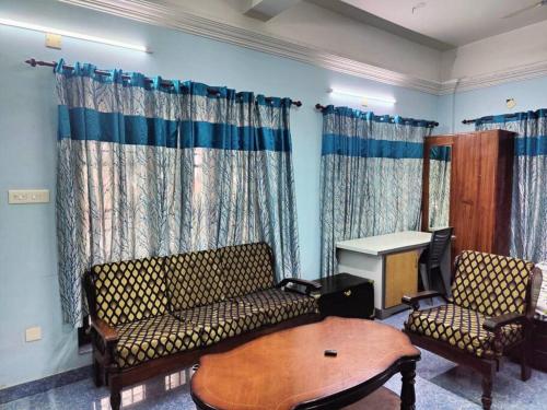 a living room with a couch and two chairs and a table at The Imperial Homestay, a faraway home. in Trivandrum