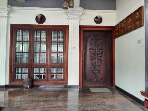 a large wooden door in a building with windows at The Imperial Homestay, a faraway home. in Trivandrum
