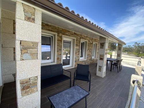 una terraza con mesa y sillas en una casa en A CASA D'ABAIXO, en Cee