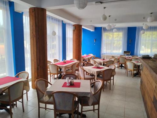 a restaurant with tables and chairs and blue walls at Pensiunea Cabana Art in Arieşeni