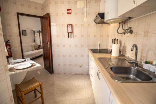 cocina pequeña con fregadero y baño en Urban Beach - A Casa dos Sonhos, en Portimão