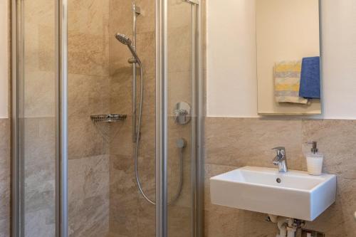 y baño con ducha y lavamanos. en Silbernagl Terrasse - Blick zum See, en Issengo