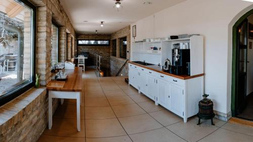 a kitchen with white cabinets and a table and a counter at BÉNI family wine farm in Cegléd