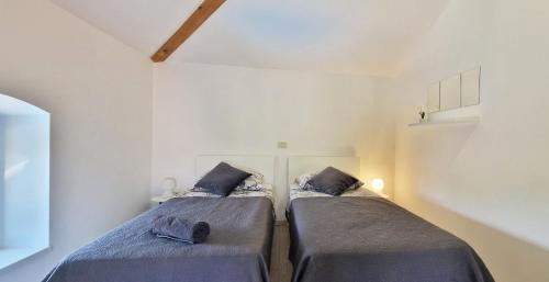 - 2 lits dans une petite chambre avec 2 oreillers dans l'établissement Beautiful Villa Casa Romito with pool in Kastelir, à Kaštelir