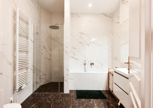 a white bathroom with a tub and a shower at Stylish Designer Apartment at the Center of Vienna Naschmarkt in Vienna