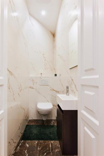 a white bathroom with a toilet and a sink at Stylish Designer Apartment at the Center of Vienna Naschmarkt in Vienna