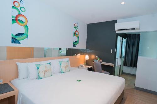 ein Schlafzimmer mit einem großen weißen Bett mit Kissen in der Unterkunft Go Hotels Iligan in Iligan