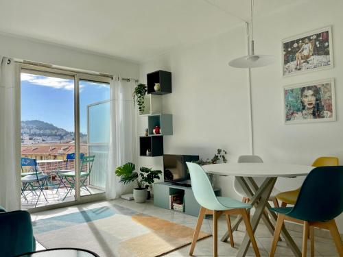 d'un salon avec une table et un balcon. dans l'établissement Risso - one bedroom with pool, newly renovated in spring 2024, à Nice