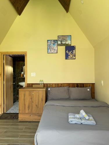a bedroom with a bed with two towels on it at Nhà Sói Homestay Da Lat in Da Lat