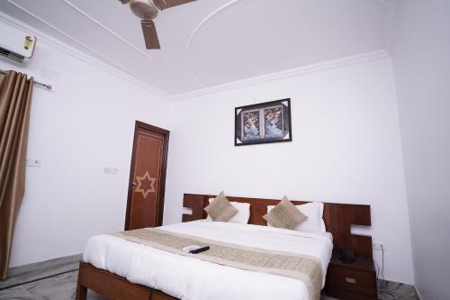 a bedroom with a bed in a white room at Hotel Lecston @Yashobhoomi Dwarka Sector - 25 metro station in New Delhi