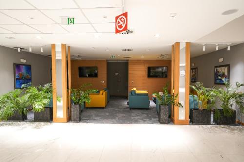 a lobby of an office building with potted plants at Hotel Park Shtip in Štip