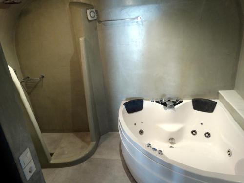 a bathroom with a bath tub and a shower at Yposkafo Suites - Studio - Santorini in Fira