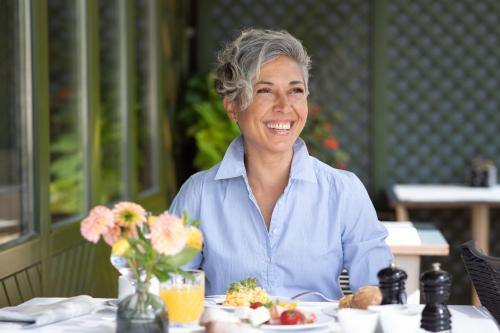 a woman sitting at a table with a plate of food at Weinlandhof in Gamlitz