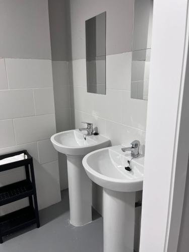 Baño blanco con 2 lavabos y espejo en Unicorn Residence for students New Opening 2024, en Valencia