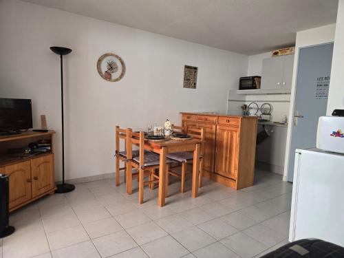 une cuisine avec une table, des chaises et un réfrigérateur dans l'établissement L'échapée Belle - Villa, résidence avec piscine et stationnement à proximité de la mer, à Vendres