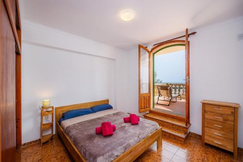 Un dormitorio con una cama con almohadas rojas. en Apartamento Voramar Mhm Cala Bona, en Cala Bona