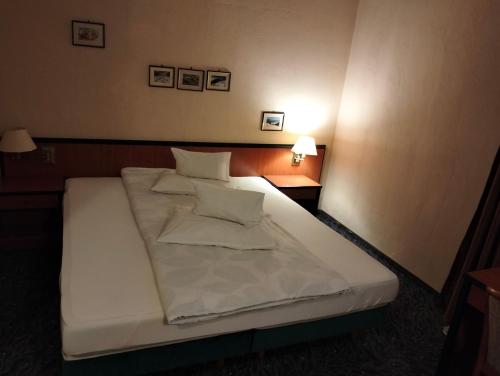 a large white bed in a small room at Pensiunea Cabana Art in Arieşeni