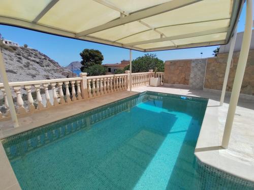 a swimming pool in a house with an umbrella at Casa Mar in Águilas
