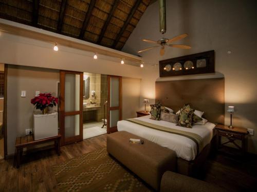 ein Schlafzimmer mit großem Bett und Couch in der Unterkunft Fairview Hotels,Spa & Golf Resort in Tzaneen