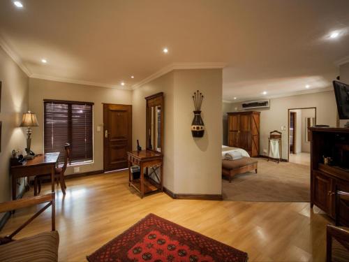 ein Wohnzimmer mit einem Sofa und einem Schreibtisch in der Unterkunft Fairview Hotels,Spa & Golf Resort in Tzaneen