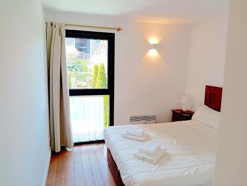 Un dormitorio con una cama blanca y una ventana. en Les Ferreries, en Saillagouse