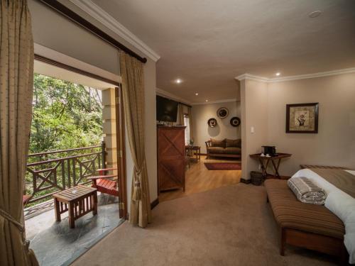 a bedroom with a bed and a balcony at Fairview Hotels,Spa & Golf Resort in Tzaneen