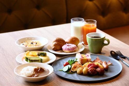a table with plates of breakfast foods and a cup of coffee at The Royal Park Canvas - Kyoto Nijo in Kyoto