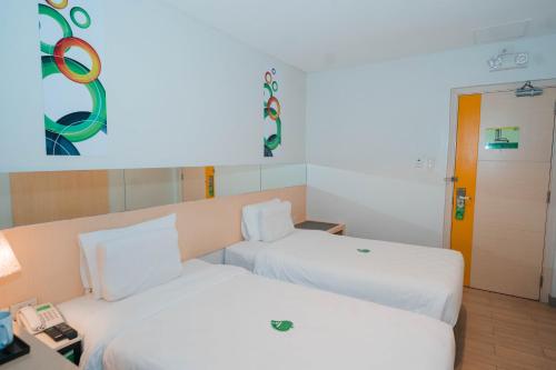 a hotel room with two beds and a phone at Go Hotels Iligan in Iligan City
