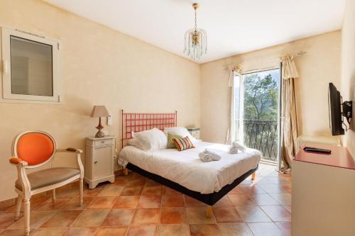 een slaapkamer met een bed, een stoel en een raam bij HappyFew Villa Lila in Saint-Martin-du-Var