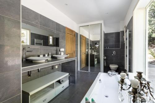 een badkamer met een bad, 2 wastafels en een bad bij HappyFew Villa Lila in Saint-Martin-du-Var