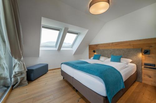 um quarto com uma cama grande e um cobertor azul em AlpenParks Hotel & Apartment Carpe Solem Mariapfarr em Mariapfarr