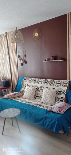 - un lit bleu dans une chambre avec une table dans l'établissement Charmant appartement vue mer, à Narbonne-Plage