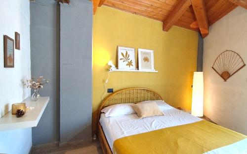 - une chambre dotée d'un lit avec un mur jaune dans l'établissement [Centro Storico] Casa con Wi-Fi e Parcheggio a 100m, à Saluces